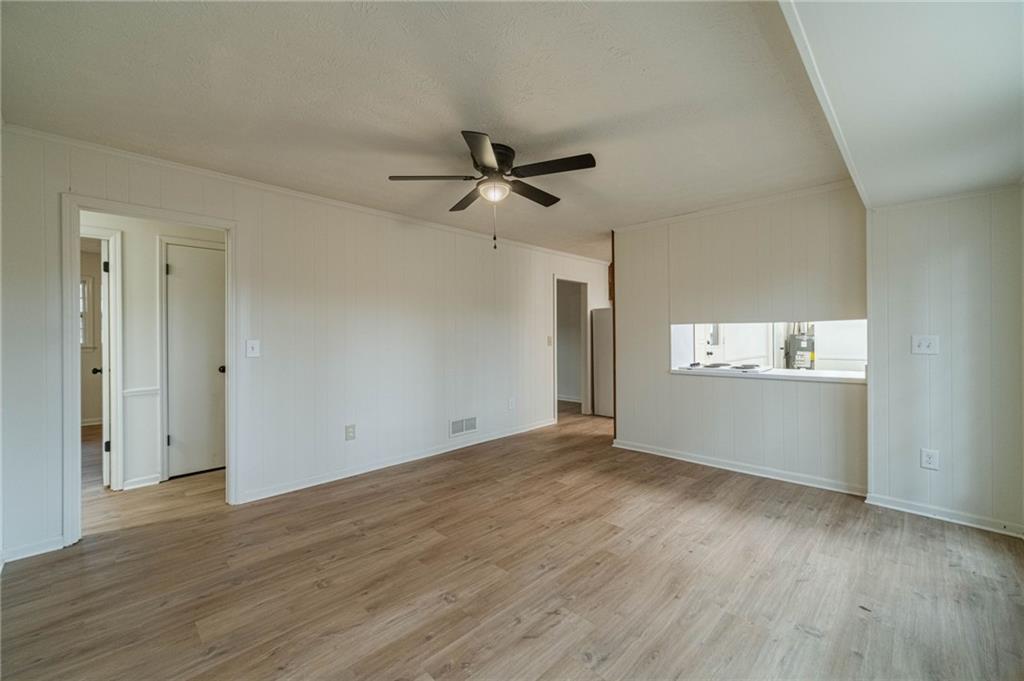 1678 Pounds Road Southwest Stone Mountain, GA 30087 - Photo 13 of 25 an empty room with wooden floor and windows