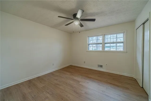an empty room with wooden floor and windows