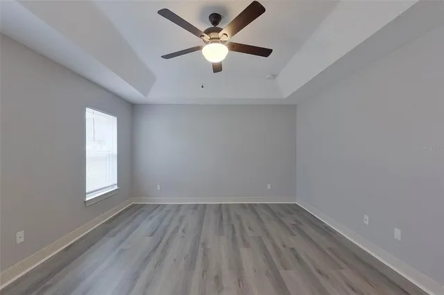 an empty room with a window and a ceiling fan