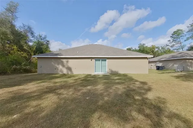 a view of a house with a backyard and a tree