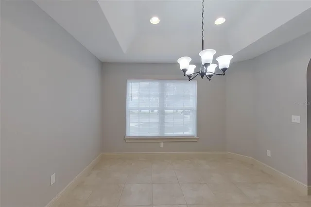 a view of a livingroom with a chandelier fan and windows