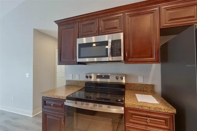 a kitchen with granite countertop a stove and a microwave