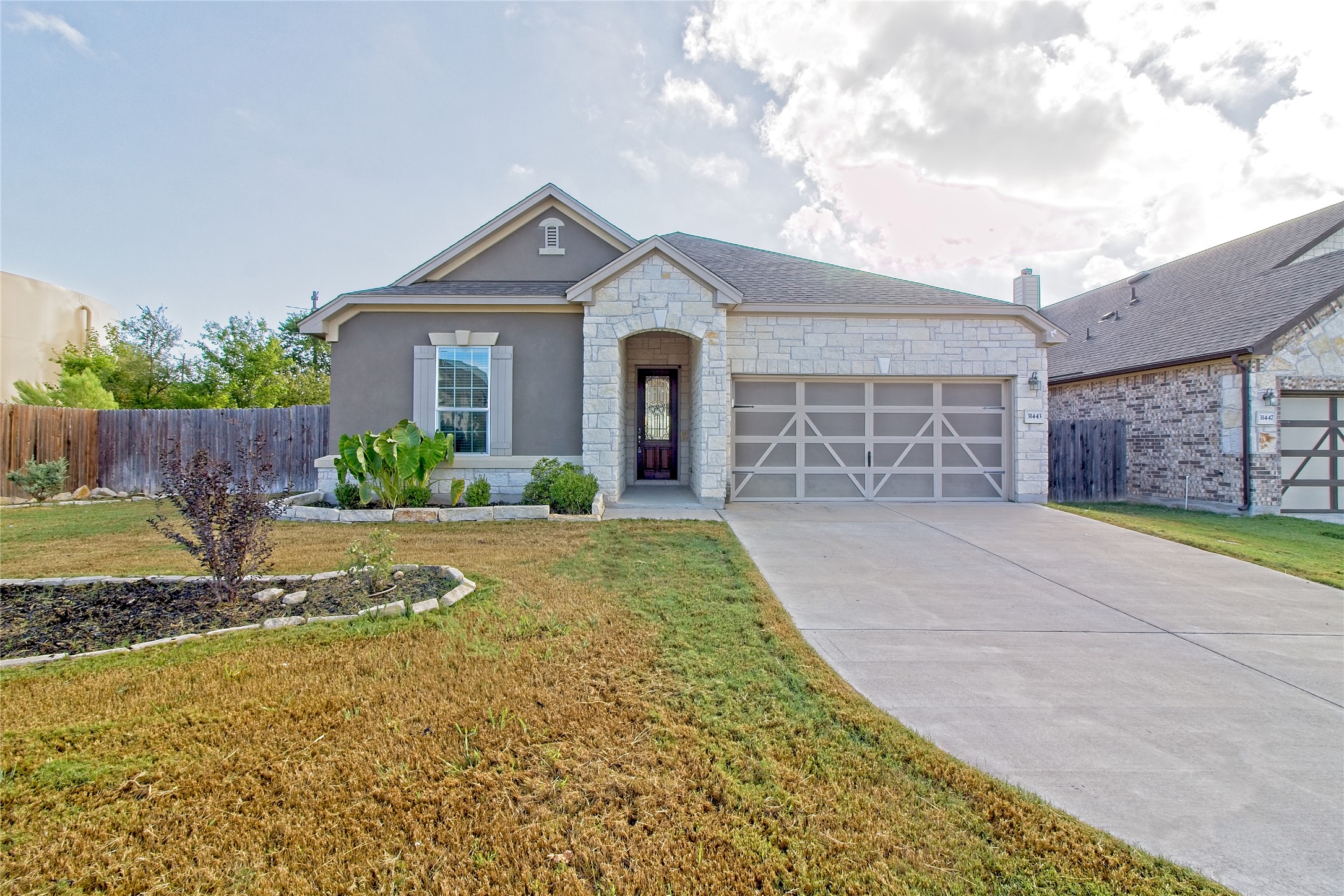31443 Kingsway Road Georgetown, TX 78628 - Photo 1 of 40 A charming single-story residence boasts a stucco and stone facade with an inviting arched entry.