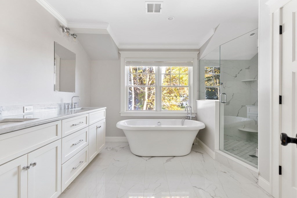 19 Turner Road Wellesley, MA 02482 - Photo 12 of 23 a bathroom with a double vanity sink a large mirror a bathtub and shower