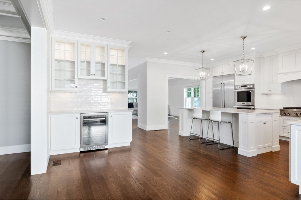 19 Turner Road Wellesley, MA 02482 - Photo 3 of 23 a kitchen with stainless steel appliances kitchen island wooden floors and white cabinets