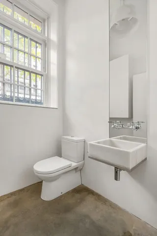 a bathroom with a sink a toilet and a mirror