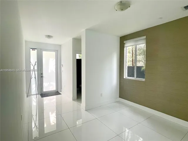 a view of an empty room with window and bathroom