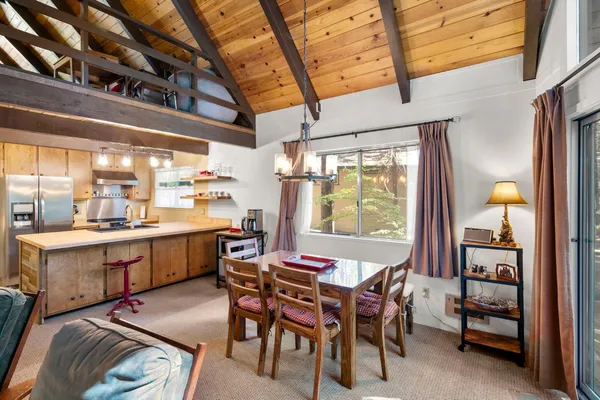 a dining room with furniture a rug a painting and a chandelier