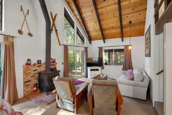 a living room with furniture a flat screen tv and a floor to ceiling window