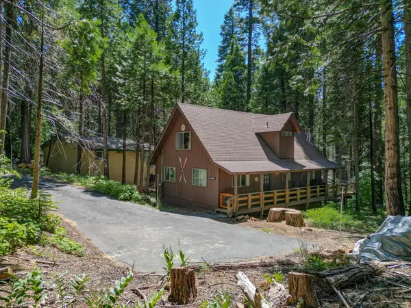 a view of a house with backyard and wooden fence