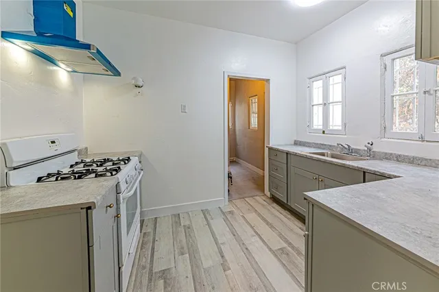 a kitchen with granite countertop a sink cabinets and stainless steel appliances