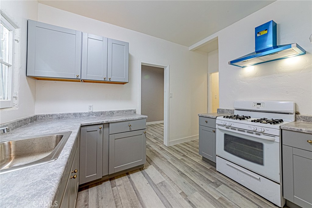 5355 West 8th Street Los Angeles, CA 90036 - Photo 22 of 32 a kitchen with granite countertop a sink cabinets and stainless steel appliances