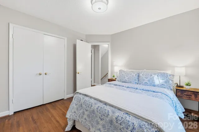 a bedroom with a bed and wooden floor