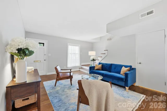 a living room with furniture and wooden floor