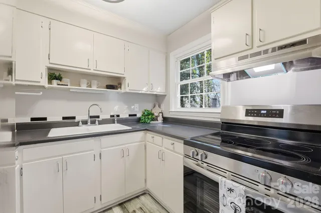 a kitchen with granite countertop white cabinets and appliances