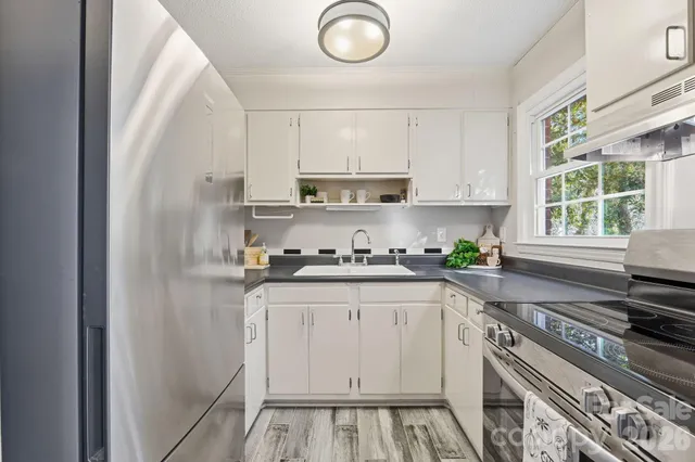 a kitchen with granite countertop a sink stainless steel appliances and cabinets