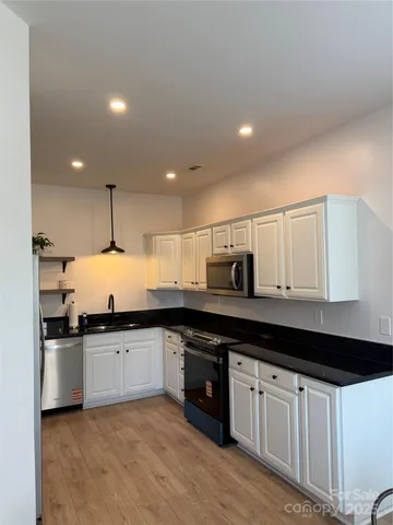 a view of an empty room with a window and fireplace