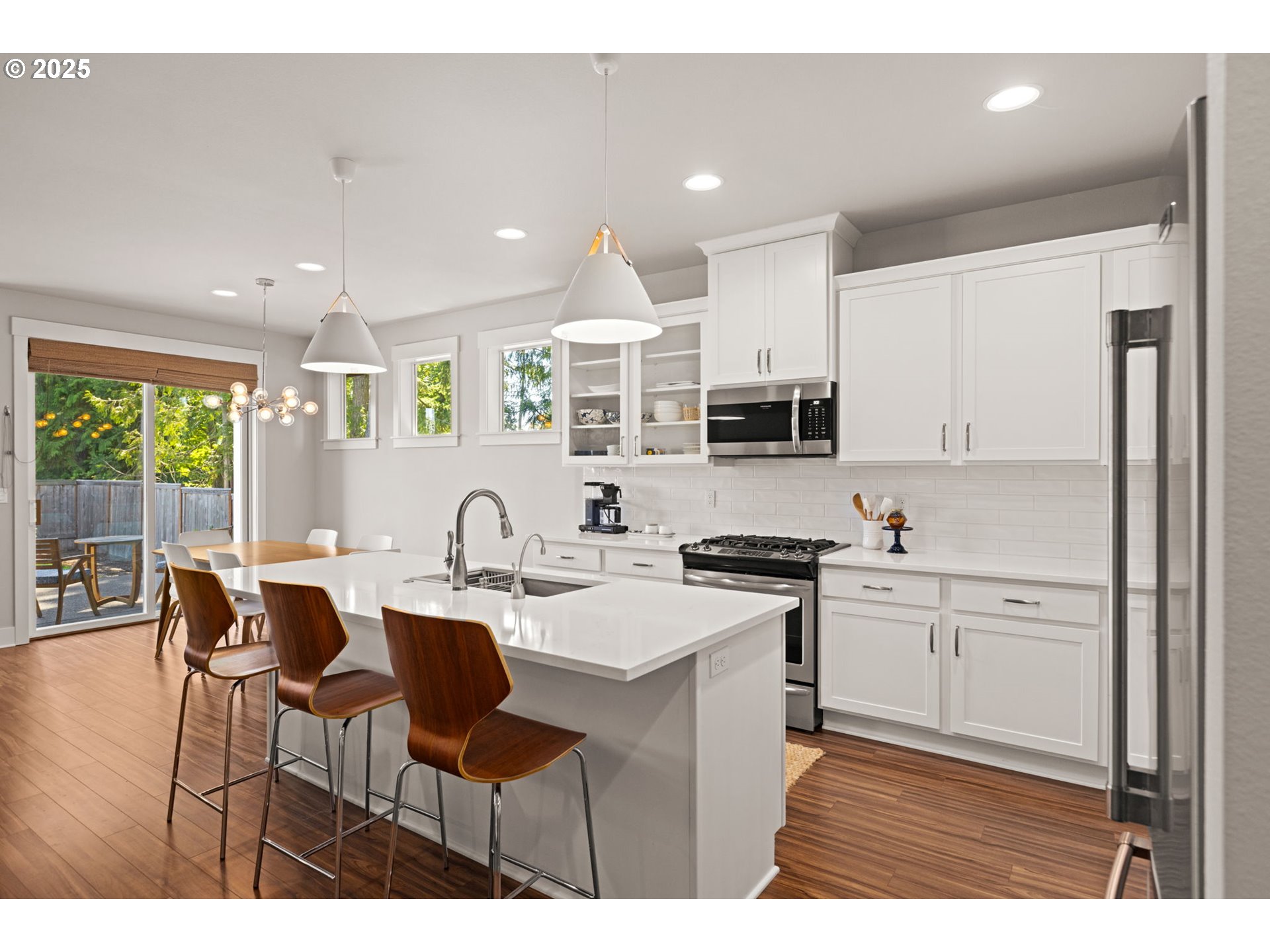 36904 Salmonberry Avenue Sandy, OR 97055 - Photo 7 of 44 a kitchen with stainless steel appliances granite countertop a stove top oven a sink dishwasher and white cabinets with wooden floor