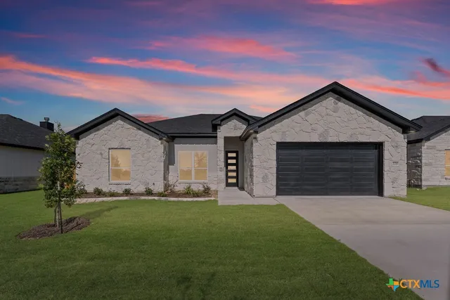 a front view of house with a garden and yard