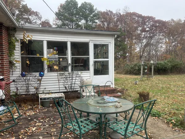 a backyard of a house with table and chairs
