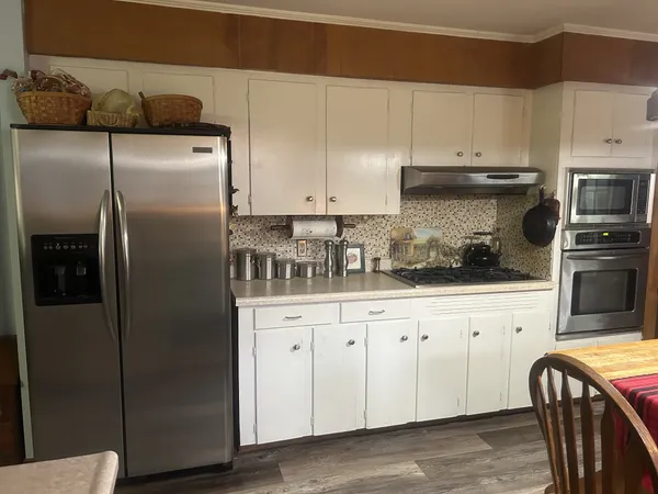 a kitchen with stainless steel appliances granite countertop a refrigerator a stove and a sink