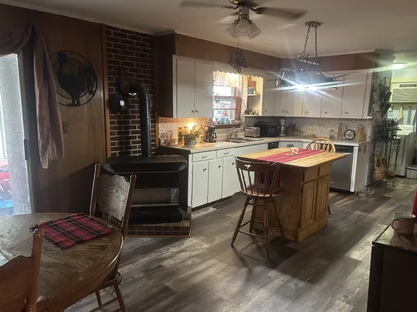 a kitchen with a stove a refrigerator and chairs