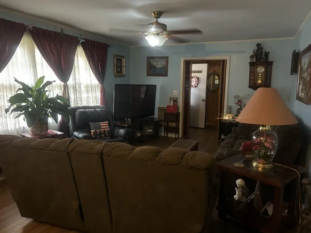 a living room with furniture a window and a flat screen tv