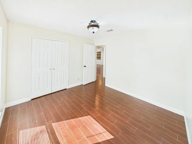 a view of an empty room with wooden floor