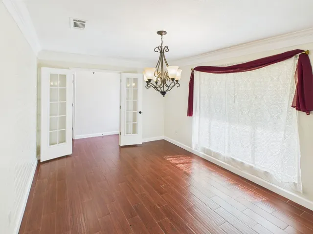 a very nice looking room with wooden floor and chandelier