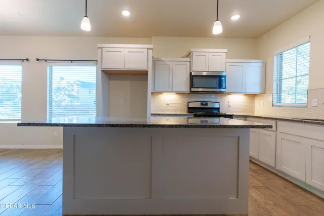 a view of a kitchen with granite countertop stainless steel appliances and wooden floor