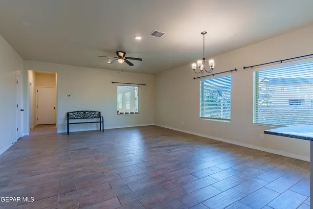 an empty room with a window and a fan