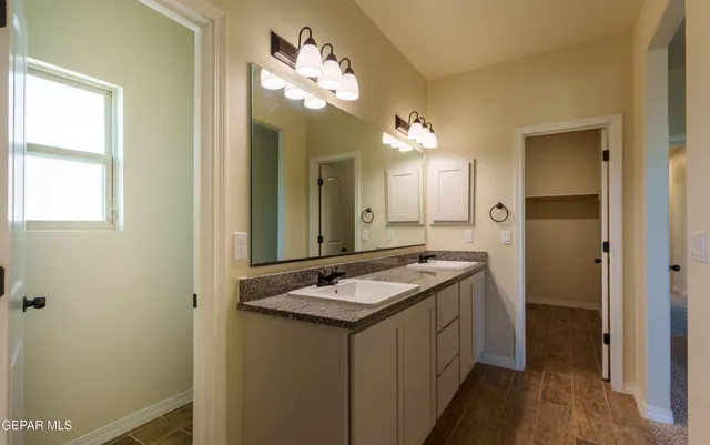 a bathroom with a sink a toilet a mirror and shower