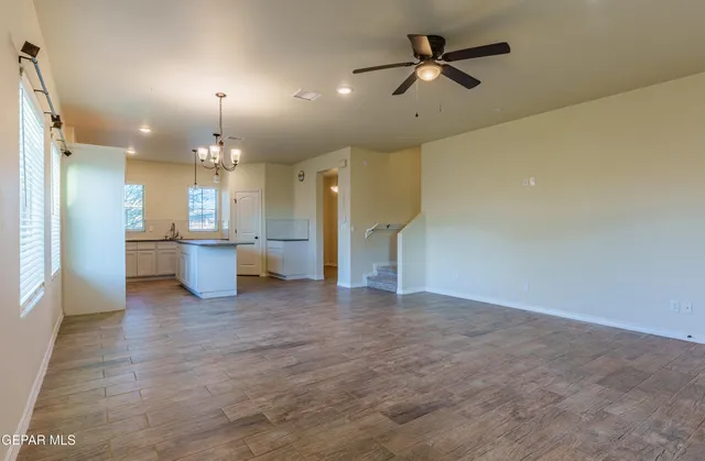 a kitchen with stainless steel appliances granite countertop a refrigerator a sink dishwasher a kitchen island with wooden floor and cabinets