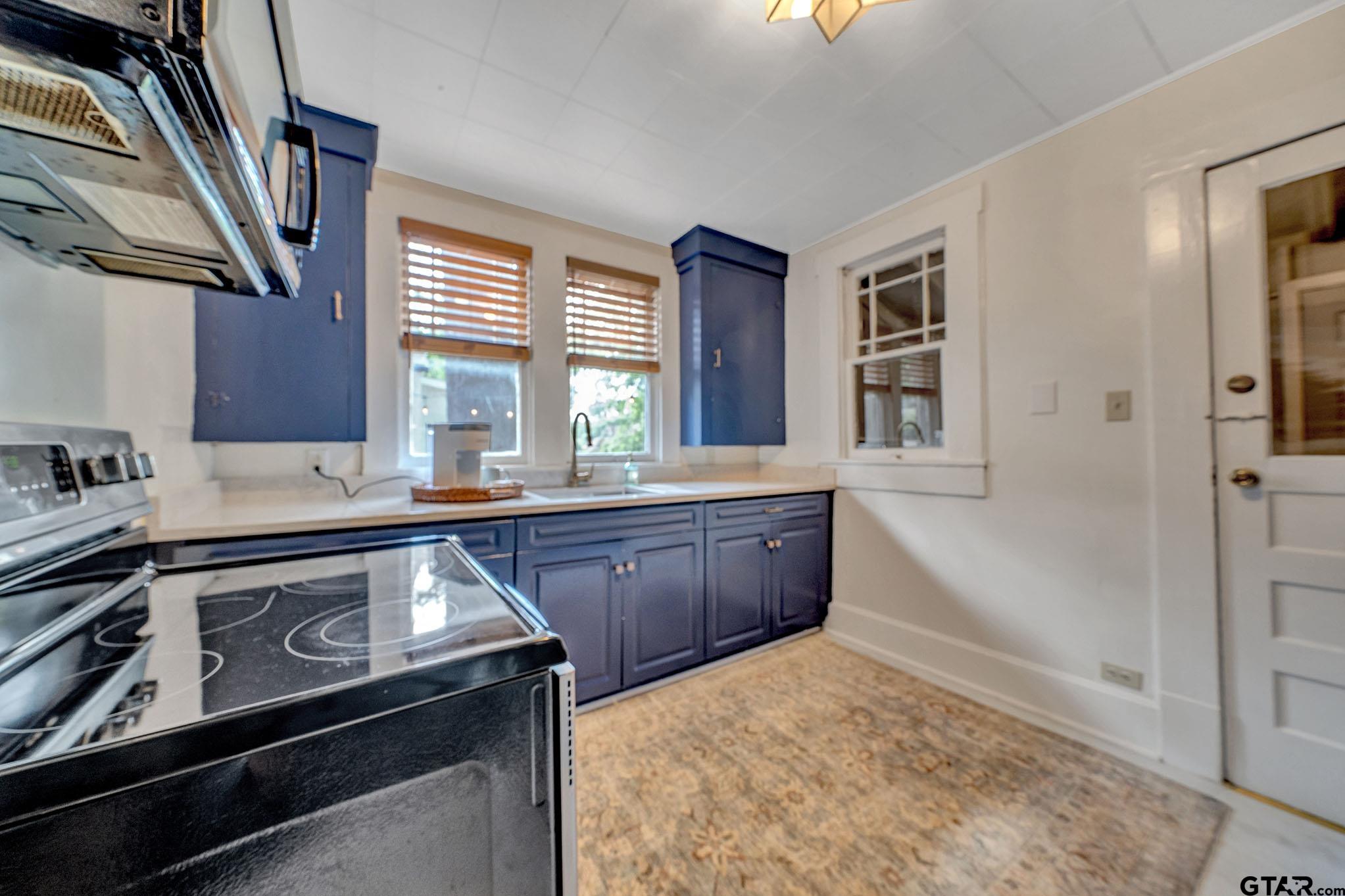 301 West Houston Street Tyler, TX 75702 - Photo 5 of 18 a kitchen with a stove a sink and a window