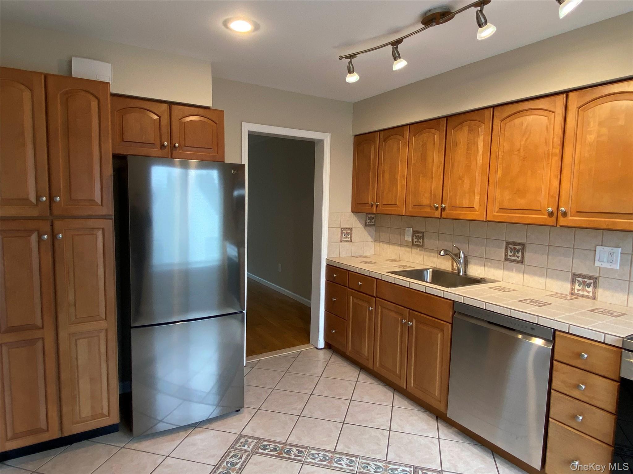 11 Wildwood Road, Unit 12 Katonah, NY 10536 - Photo 7 of 17 a kitchen with stainless steel appliances granite countertop a refrigerator and a sink