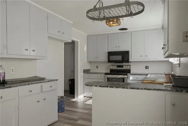 a kitchen with stainless steel appliances granite countertop a sink a window and cabinets