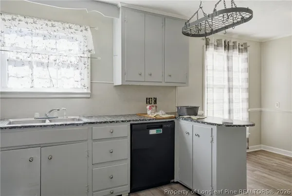 a kitchen with granite countertop white cabinets and stainless steel appliances