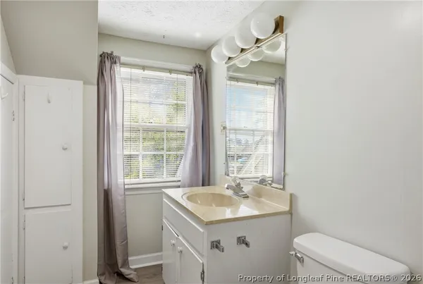 a bathroom with a toilet a sink and mirror