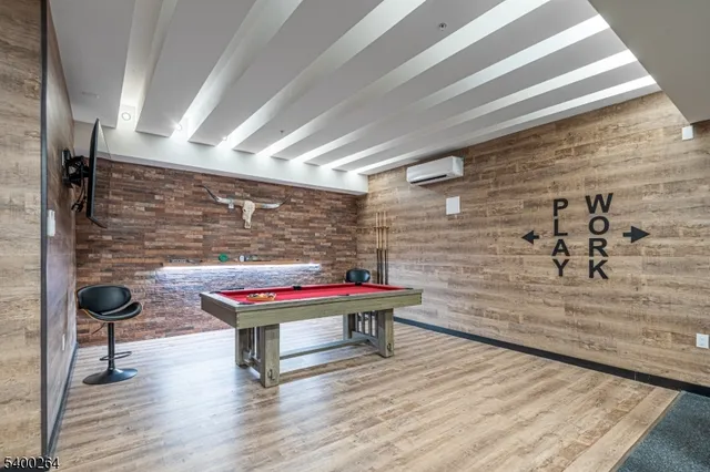 a room with pool table and a wooden floor