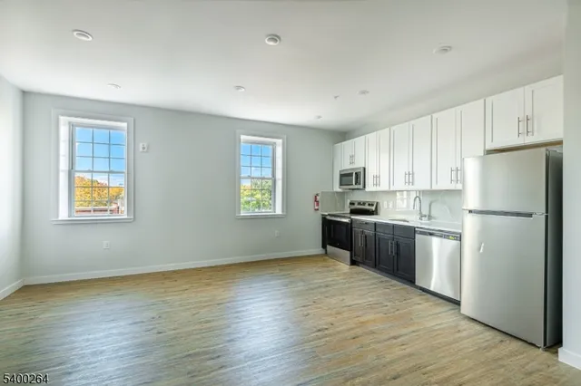 a kitchen with a refrigerator sink and cabinets