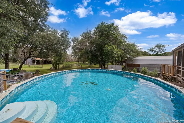 a view of a backyard with swimming pool