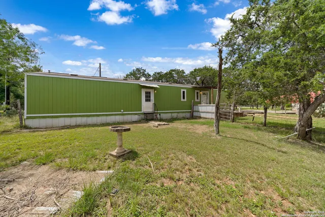 a green field with lots of trees in the background