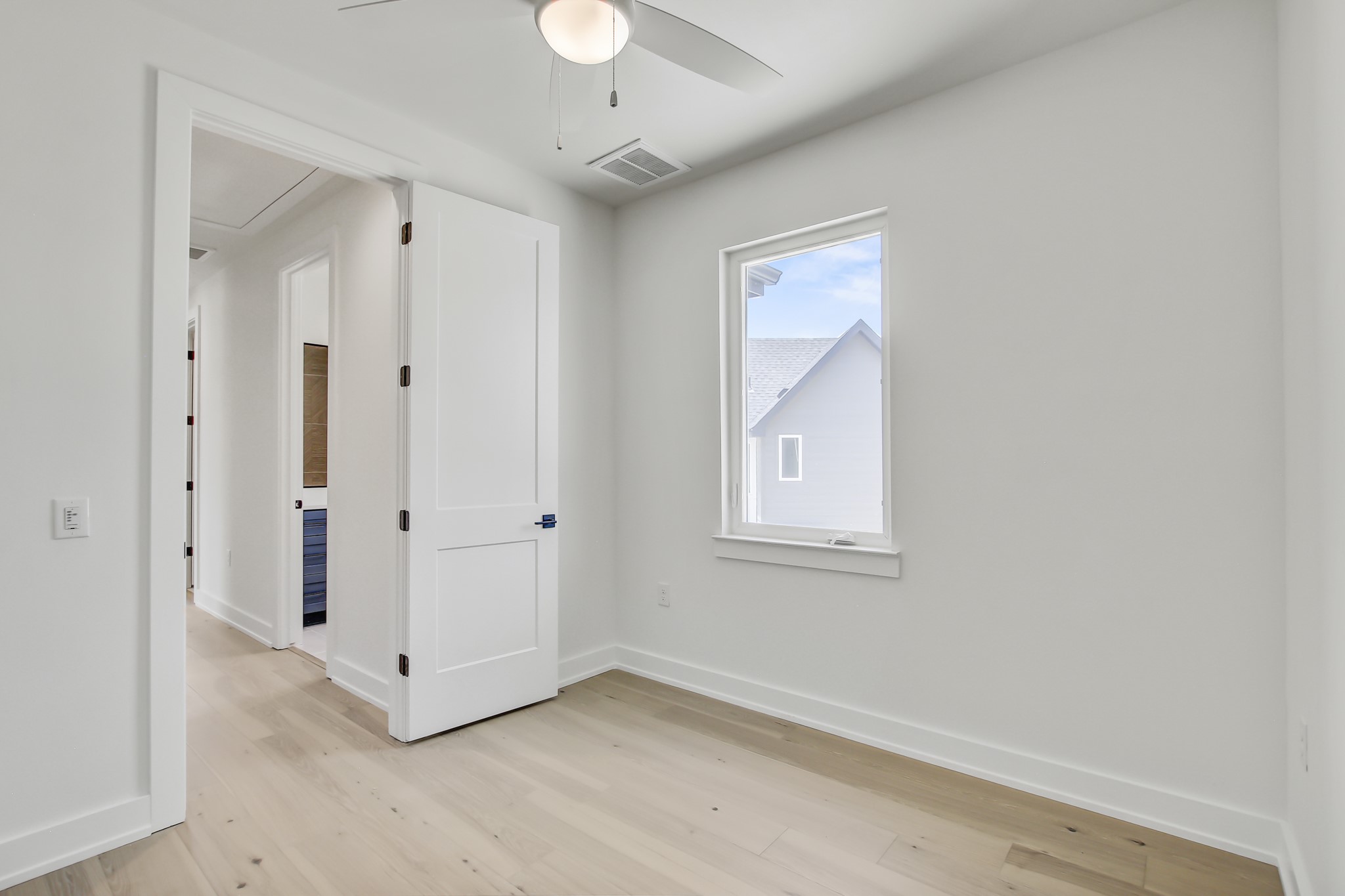4127 East 12th Street, Unit 8 Austin, TX 78721 - Photo 27 of 32 Empty room with attic access, ceiling fan, light wood-style flooring, and baseboards