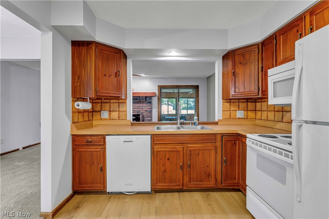 6635 Taylor Road Painesville, OH 44077 - Photo 17 of 41 Kitchen featuring wood-finish cabinetry, solid surface countertops, and a tiled backsplash