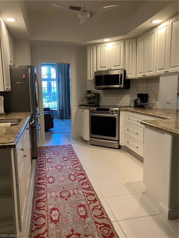4080 Trinidad Way Naples, FL 34119 - Photo 4 of 15 a large kitchen with stainless steel appliances granite countertop a stove top oven a sink and dishwasher