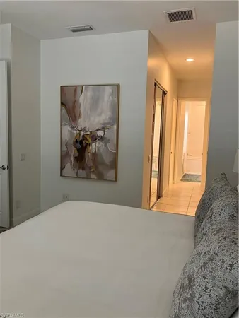 a bedroom with a large bed and a painting on the wall