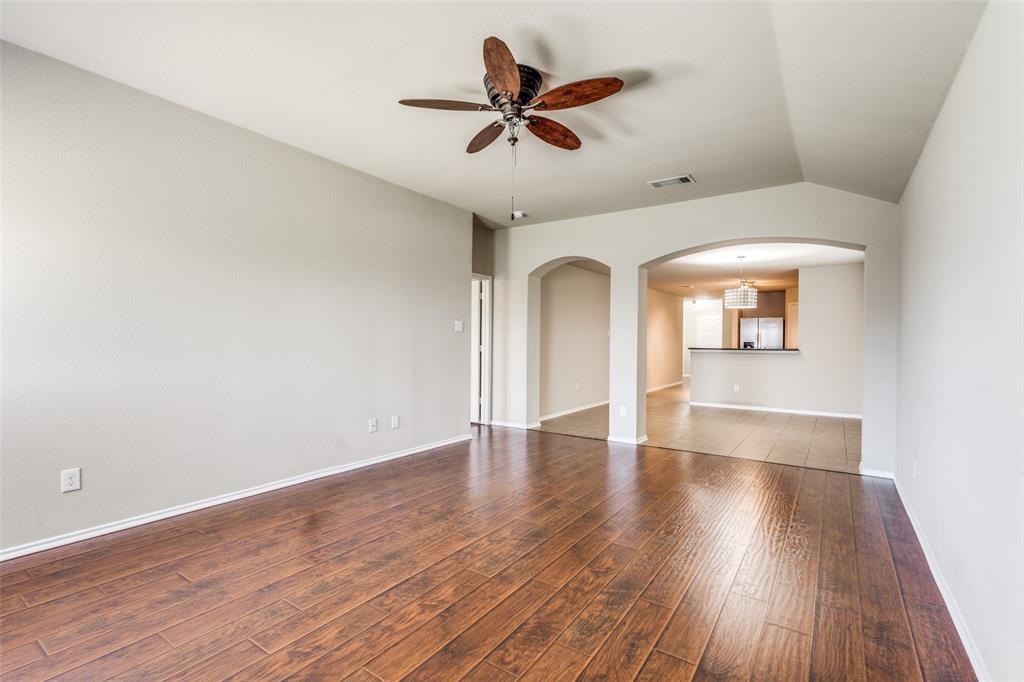 1101 Rainer Drive Princeton, TX 75407 - Photo 12 of 25 an empty room with wooden floor and ceiling fan