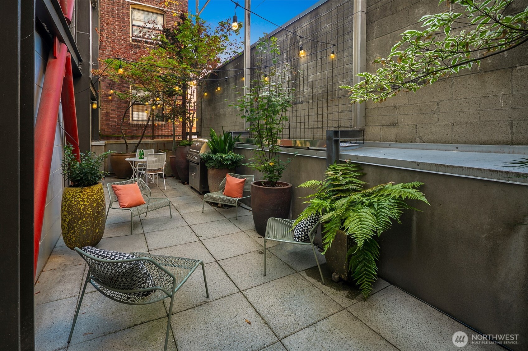 1310 East Union Street, Unit 202 Seattle, WA 98122 - Photo 14 of 31 a backyard of a house with lots of green space and glass windows