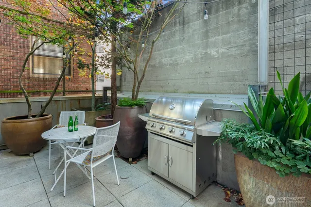 a patio with a table and chairs and potted plants