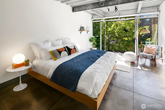 a bed sitting in a bedroom next to a large window